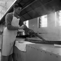 "Ai Lam - HK*" Man stirring some boiling liquid in an industrial kitchen.