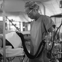 An American nurse is monitoring the breathing of a patient.