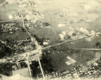"Before and After near Thanh Hoa, North Vietnam - Navy jet pilots of Carrier Air Wing 15 pounded a railroad ferry complex northeast of Thanh Hoa Sep. 21-23, 1966. Targets included a thermal power plant, defending flak sites, railways, boxcars, and roads. After the raid shown in these before and after photos, Navy Intruder and Skyhawk pilots described the area as 'devastated.'" Aerial photo of a bombed landscape with roads, a village, a railway, and farms.