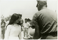 "A gift of thanks--A Vietnamese high school girl shyly presents Seabee Lieutenant Commander G.R. Gilmore, operations officer of U.S. Naval Mobile Construction Battalion Eight, a watermelon in appreciation of the battalion's construction accomplishments in her province of Binh Son, South Vietnam." Girl from Binh Son Province presents watermelon to an American military official. Seabees news release 170-67 (55).