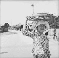"Ca Mau" Young Vietnamese girl with a basket on her head.