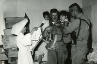 "Sister Mary Angela and Maj. John Arguiette at Orphanage." A Vietnamese Catholic nun stands with two American soldiers. One holds two Vietnamese children in his arms.
