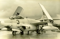 "The EF10B 'Skynight' is a two-plane twin-jet aircraft utilizing electronics to provide intelligence and countermeasures." A US Marine Corps jet sitting in an wet airfield.