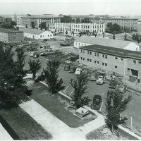 Temporary buildings in foreground, with Burnett Hall under construction. Partially demolished old Nebraska Hall is in the upper left corner.