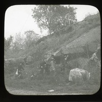 Original caption: The flint ledge at old quarry opp. So. Bend, Nebr. 1911 Group of men standing at base of flint ledge. Cass County. (121111-00247)